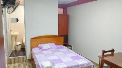 a small bedroom with a bed and a sink at Hospedaje El Sureño in Satipo