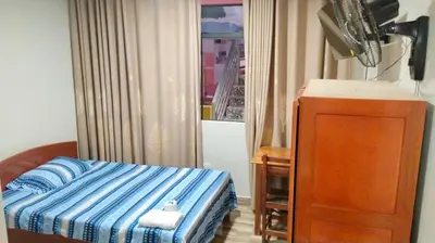 a bedroom with a bed and a dresser and a window at Hospedaje El Sureño in Satipo