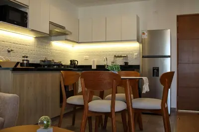 a kitchen with a table with chairs and a refrigerator at Brand new apartment in Olivar of San Felipe in Lima