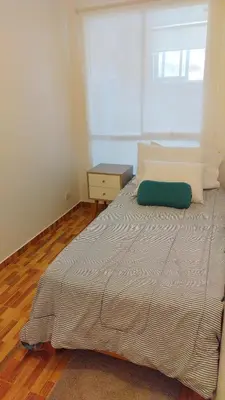 a bedroom with a bed with a green pillow on it at Alojate en Mala casa del valle in Mala