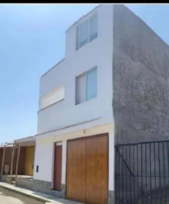 a white house with two doors and a fence at Alojate en Mala casa del valle in Mala