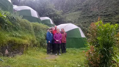a group of people standing in front of tents at Chaullay Star Domes in Colcapampa
