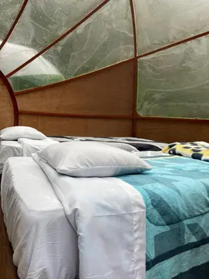 a couple of beds in a room with a window at Chaullay Star Domes in Colcapampa