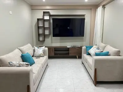 a living room with two couches and a flat screen tv at Departamento cómodo para una estancia feliz in Ayacucho