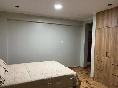 a bedroom with a bed and a wooden cabinet at Departamento cómodo para una estancia feliz in Ayacucho