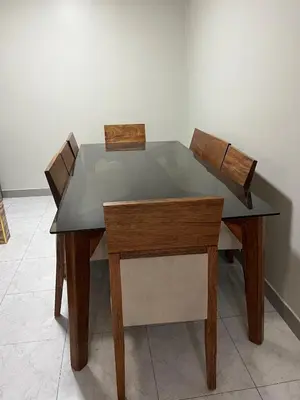 a wooden table with two chairs and a glass top at Departamento cómodo para una estancia feliz in Ayacucho