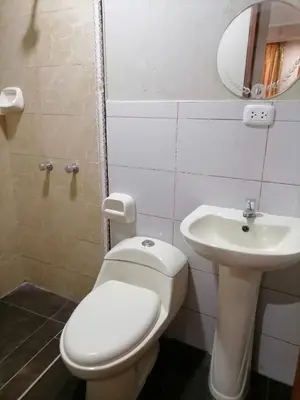 a bathroom with a white toilet and a sink at Departamento cómodo para una estancia feliz in Ayacucho