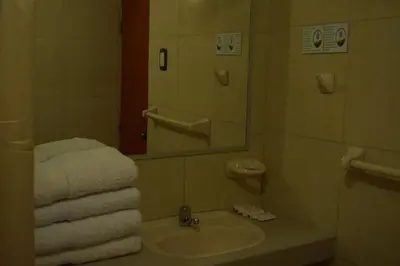 a bathroom with a sink and a mirror and towels at Belle Sand Hotel in Ica