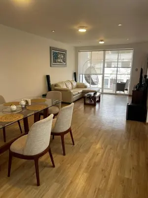 a living room with a table and chairs and a couch at Amplio y acogedor departamento de 130m2 - 2do piso in Lima