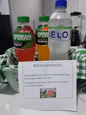 two bottles of ev drinks on a table with a sign at Alojamiento Flower House in San Antonio