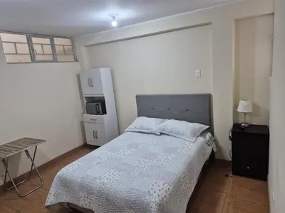 a small bedroom with a bed and a refrigerator at Habitación privada 2do piso cerca a la Plaza Constitución in Huancayo