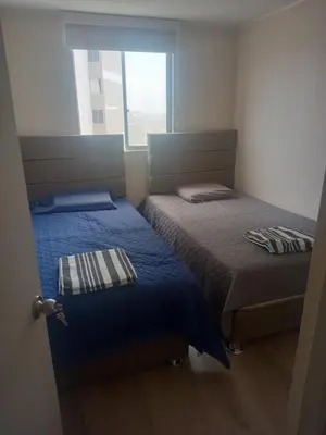 two beds in a small room with a window at Alto Alborada Cercado in Lima
