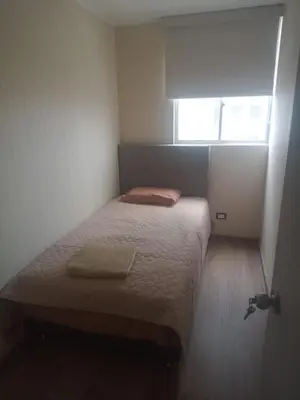 a small bedroom with a bed and a window at Alto Alborada Cercado in Lima