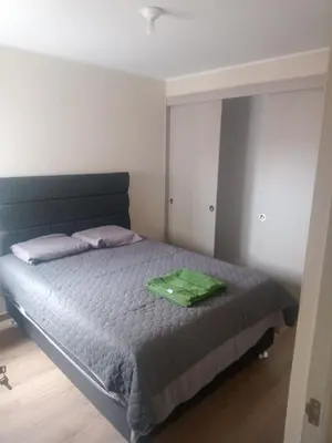 a bedroom with a bed with a green pillow on it at Alto Alborada Cercado in Lima
