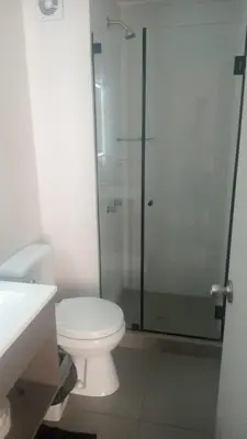 a bathroom with a toilet and a glass shower at Alto Alborada Cercado in Lima