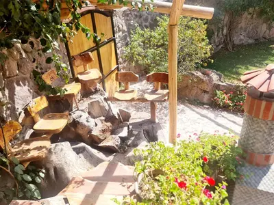 a garden with chairs and a fence and flowers at Arins House in Cusco