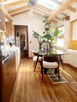 a kitchen with a dining room table with a vase of flowers at Arins House in Cusco