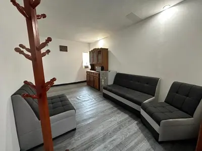 a living room with two couches and a kitchen at Habitaciones para Turistas en Zona Tranquila de Cusco in Cusco