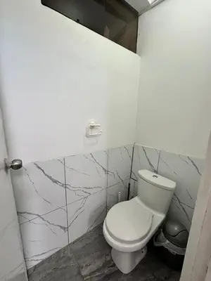 a bathroom with a white toilet and marble walls at Habitaciones para Turistas en Zona Tranquila de Cusco in Cusco
