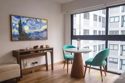 a living room with a table and chairs and a painting at Elegant and cozy 2BR in Miraflores by Eco28 in Lima