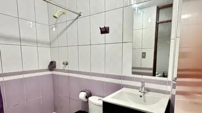 a bathroom with a sink and a toilet and a mirror at Habitación tranquila a 15 min de Plaza Norte in Lima