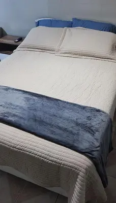 a white bed with blue sheets and blue pillows at Monoambiente a 20 minutos del Aeropuerto, moderno y privado in Lima