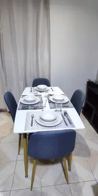 a white table with chairs and plates on it at Monoambiente a 20 minutos del Aeropuerto, moderno y privado in Lima