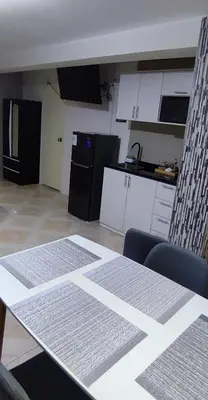 a kitchen with white cabinets and a table in a room at Monoambiente a 20 minutos del Aeropuerto, moderno y privado in Lima