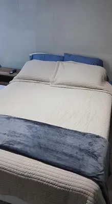 a large bed with blue pillows on top of it at Monoambiente a 20 minutos del Aeropuerto, moderno y privado in Lima