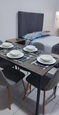 a dining room table with plates on it next to a bed at Monoambiente Parque Naranjal B, a 20 minutos del Aeropuerto - Hasta 3 huéspedes in Lima