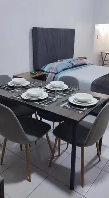 a dining table with plates on it next to a bed at Monoambiente Parque Naranjal B, a 20 minutos del Aeropuerto - Hasta 3 huéspedes in Lima
