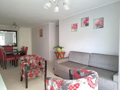 a living room with a couch and chairs and a table at Apartamento en condominio cerca a Plaza Norte in Lima