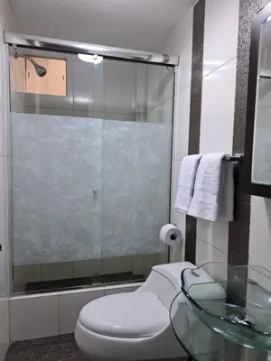 a bathroom with a toilet and a glass table at Apartamento en condominio cerca a Plaza Norte in Lima