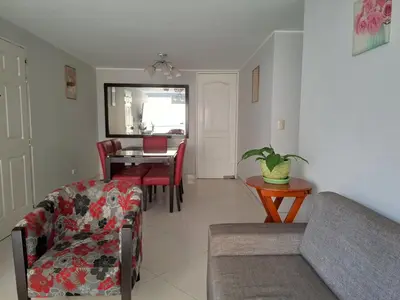 a living room with a couch and a table at Apartamento en condominio cerca a Plaza Norte in Lima