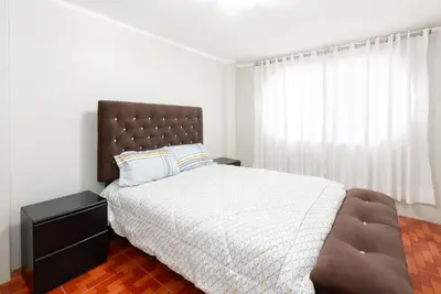 a bedroom with a large bed with a brown headboard at Alameda Suite Ayacucho in Ayacucho