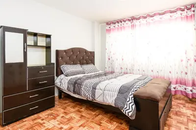 a bedroom with a bed and a dresser and a mirror at Alameda Suite Ayacucho in Ayacucho