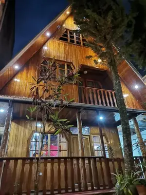 a wooden house with trees in front of it at La Cabaña del Tony in Villa Rica