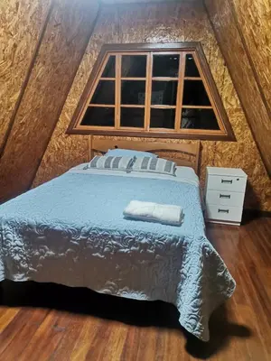 a bedroom with a bed and a window at La Cabaña del Tony in Villa Rica