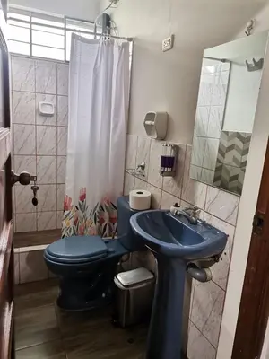 a bathroom with a blue toilet and a sink at La Cabaña del Tony in Villa Rica