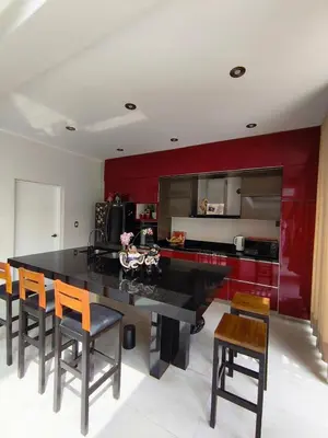 a kitchen with red cabinets and a large black table at La Morada del Sol in Cieneguilla