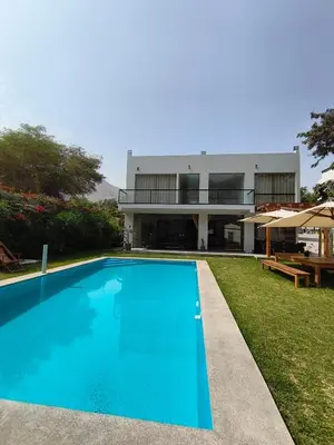 a swimming pool in front of a house at La Morada del Sol in Cieneguilla