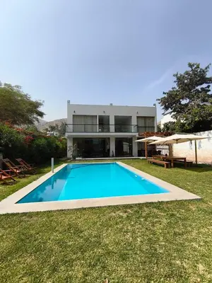 a swimming pool in front of a house at La Morada del Sol in Cieneguilla
