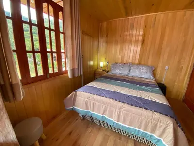 a bedroom with a bed in a wooden room at Cabañas Don Ceferino in Palmira