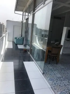 a balcony with a table and a desk on a building at Miraflores Penthouse in Lima