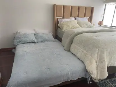 two beds sitting next to each other in a bedroom at Departamento en Santiago de Surco in Lima