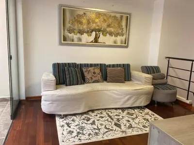 a white couch in a living room with a painting at Departamento en Santiago de Surco in Lima
