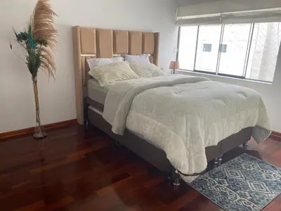 a bedroom with a large bed with a large window at Departamento en Santiago de Surco in Lima