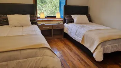 two beds sitting in a room with a window at Country house in nature in Sacred Valley in Huayllabamba