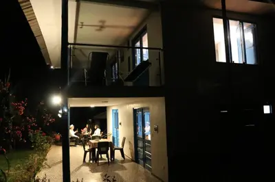 a house with a balcony with people sitting at a table at Country house in nature in Sacred Valley in Huayllabamba