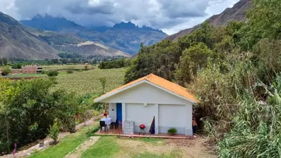 a small white shed on the side of a mountain at Cottage in nature in Sacred Valley with mountain views in Huayllabamba